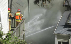 Firefighters attend the scene of a house fire in Kelburn.