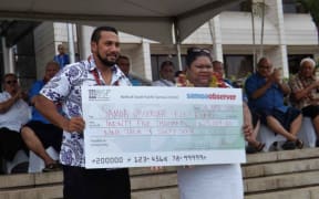 Samoa Observer Editor Mata'afa Keni Lesa, presenting the US15,000  to the Olympic silver medalist, Ele Opeloge.