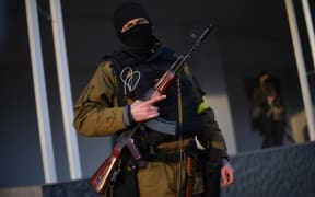 EDITORS NOTE: Graphic content / Armed civilian volunteers stand alert on a street in Kyiv on February 25, 2022. - Russian forces reached the outskirts of Kyiv on February 25, as Ukrainian President said the invading troops were targeting civilians