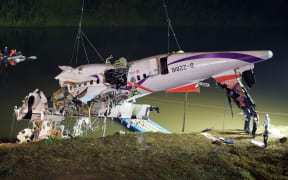 Rescuers lift the wreckage of the TransAsia ATR 72-600 out of the Keelung river at New Taipei City on February 4, 2015.