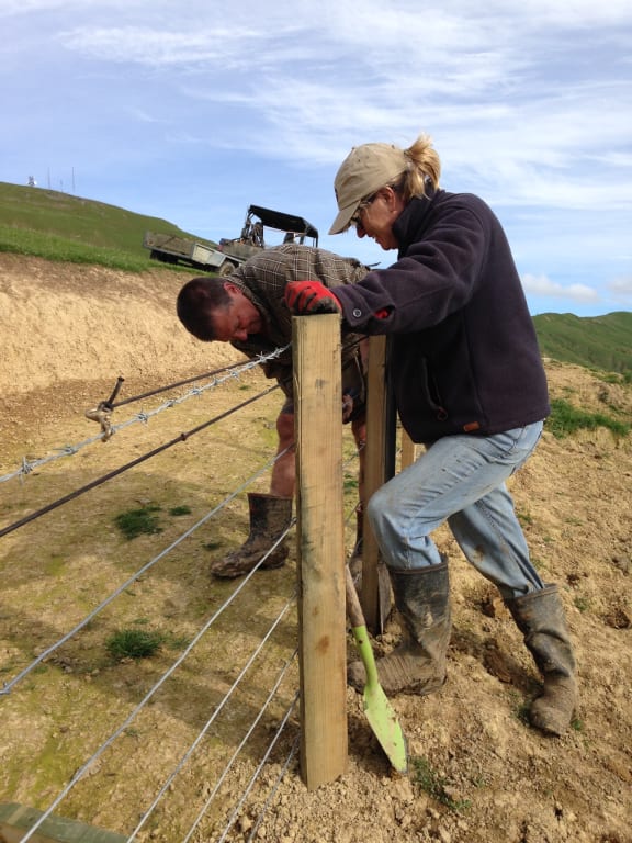 Roger and Barb Barton work on fencing at their boundary.
