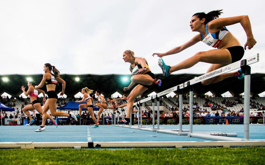 Competitors jump in the Women 100 Metre Hurdles