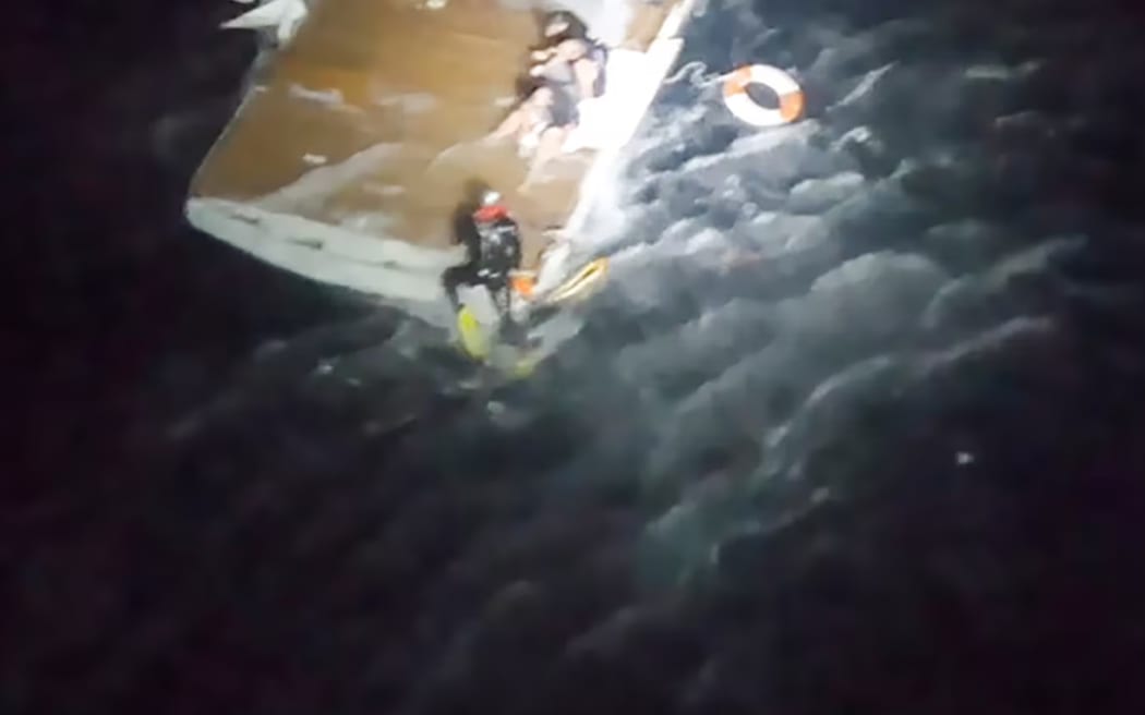A helicopter crew rescues men from the wave-smashed charter-fishing vessel The Enchanter, skippered by Lance Goodhew.