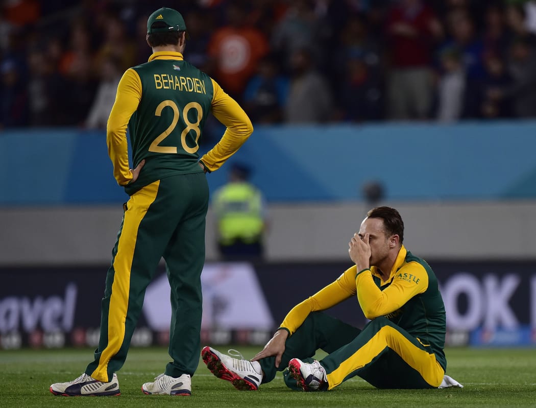 South Africa's Faf du Plessis (R) sits dejected on the field with teammate Farhaan Behardien after their loss.