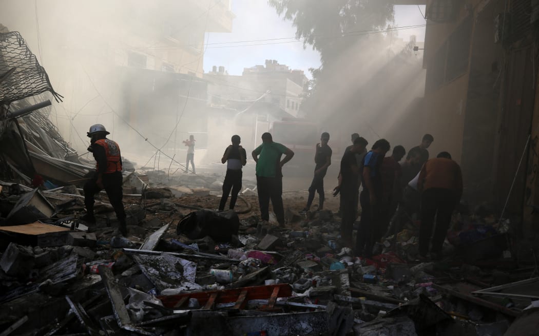 People assess the destruction cause by Israeli air strikes in Gaza City.