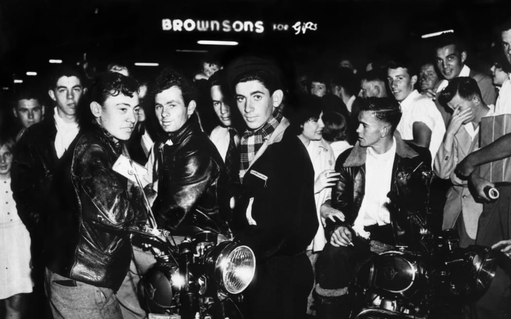 Historic: Youth
Milk Bar Cowboys with their motorbikes in Queen Street, Auckland, in the 1950's    
New Zealand Herald  21 Sep 1956.
NZH 25jan03 - BODGIES : Auckland's " milk bar cowboys, " whose look is typified by this group, caused disruption on Queen St in 1955.