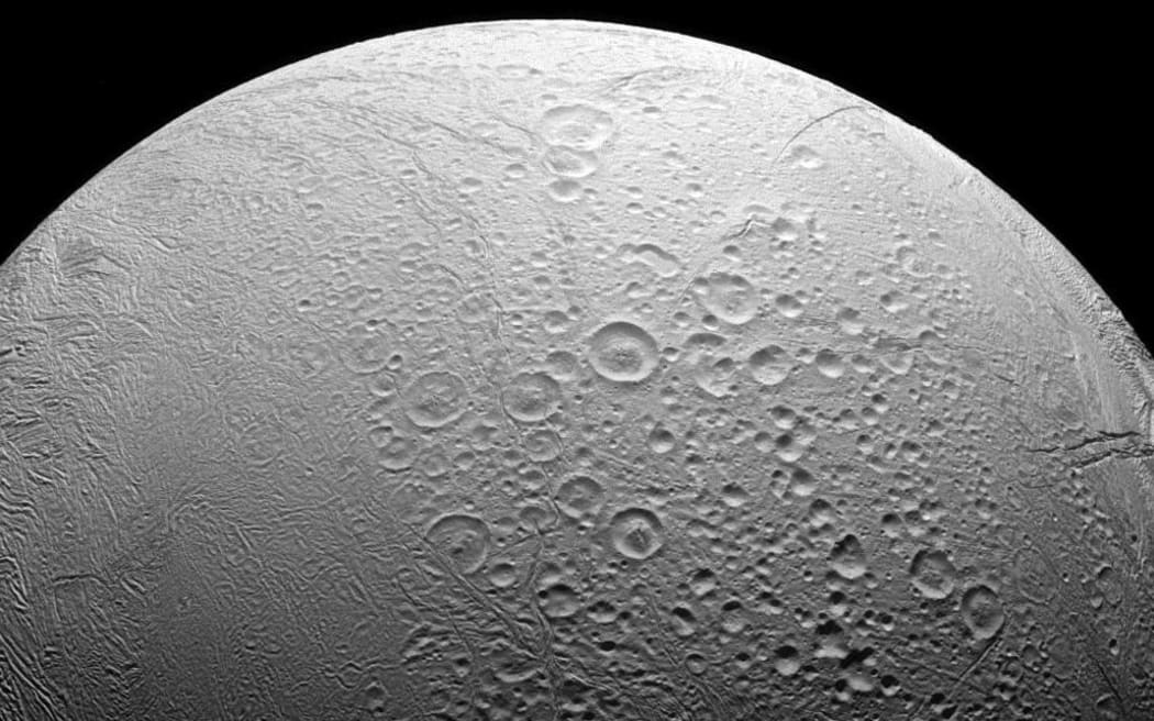 Enceladus, to the north are craters and evidence of the many impacts the moon has suffered in its history.