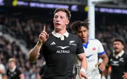 Cam Roigard of the All Blacks celebrates his try.