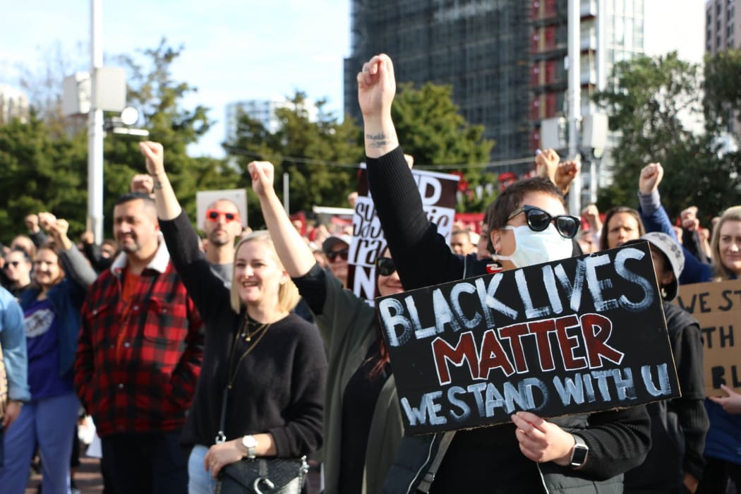 Protesters raise their fists to show solidarity at the Black Lives Matter march in Auckland on 14 June, 2020.