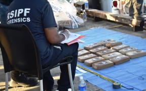 A Forensic officer in Solomon Islands recording the amount of cocaine being off-loaded from the yacht Vieux Malin in Honiara.