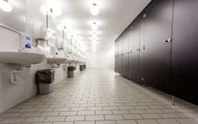 Mens restroom in an public building in white and black doors