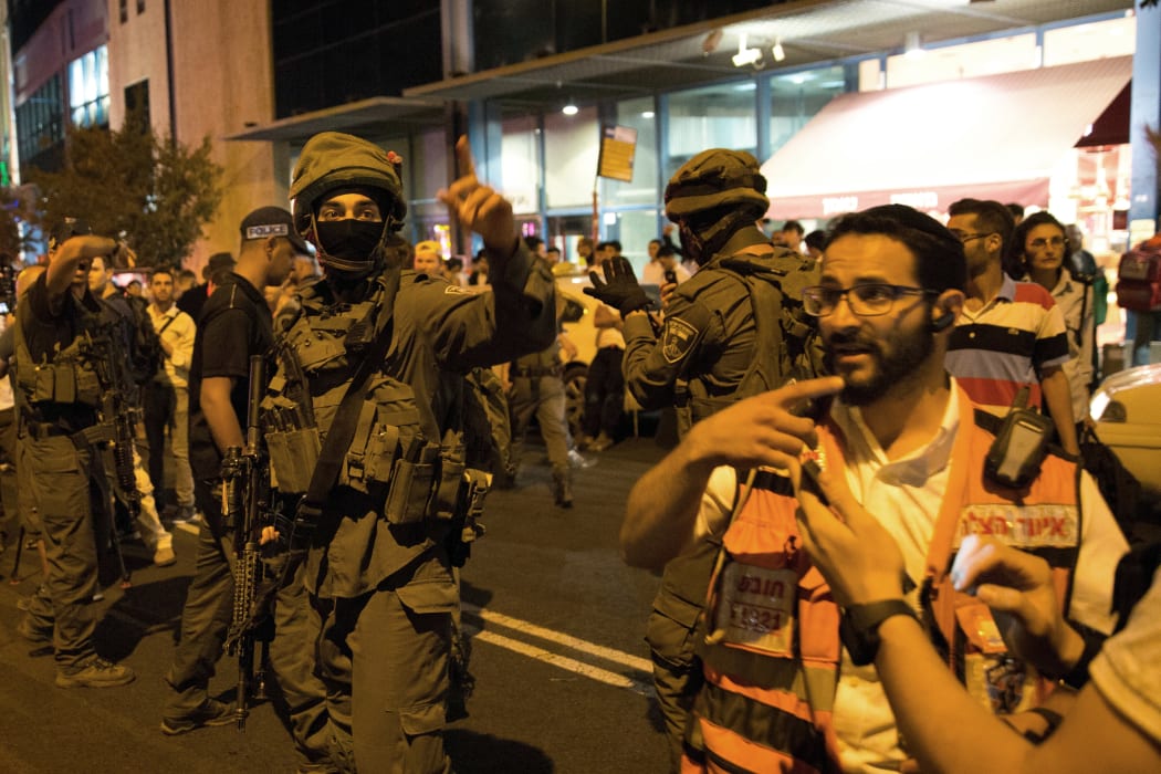 Israeli security forces, police and a medical team arrive at the site where a knife-wielding man stabbed and moderately wounded a woman near Jerusalem's central bus station on October 14, 2015.