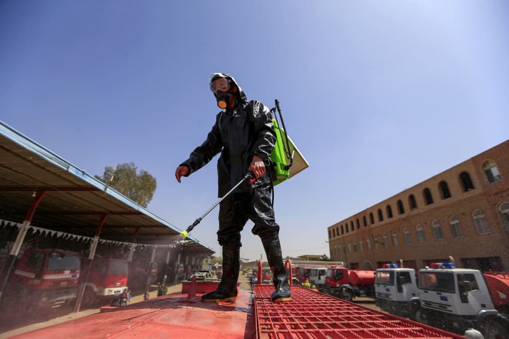 A member of the Yemeni Civil Defense sprays disinfectant on a tank truck in the Yemeni capital Sanaa amid the coronavirus (COVID-19) pandemic, on April 12, 2020.