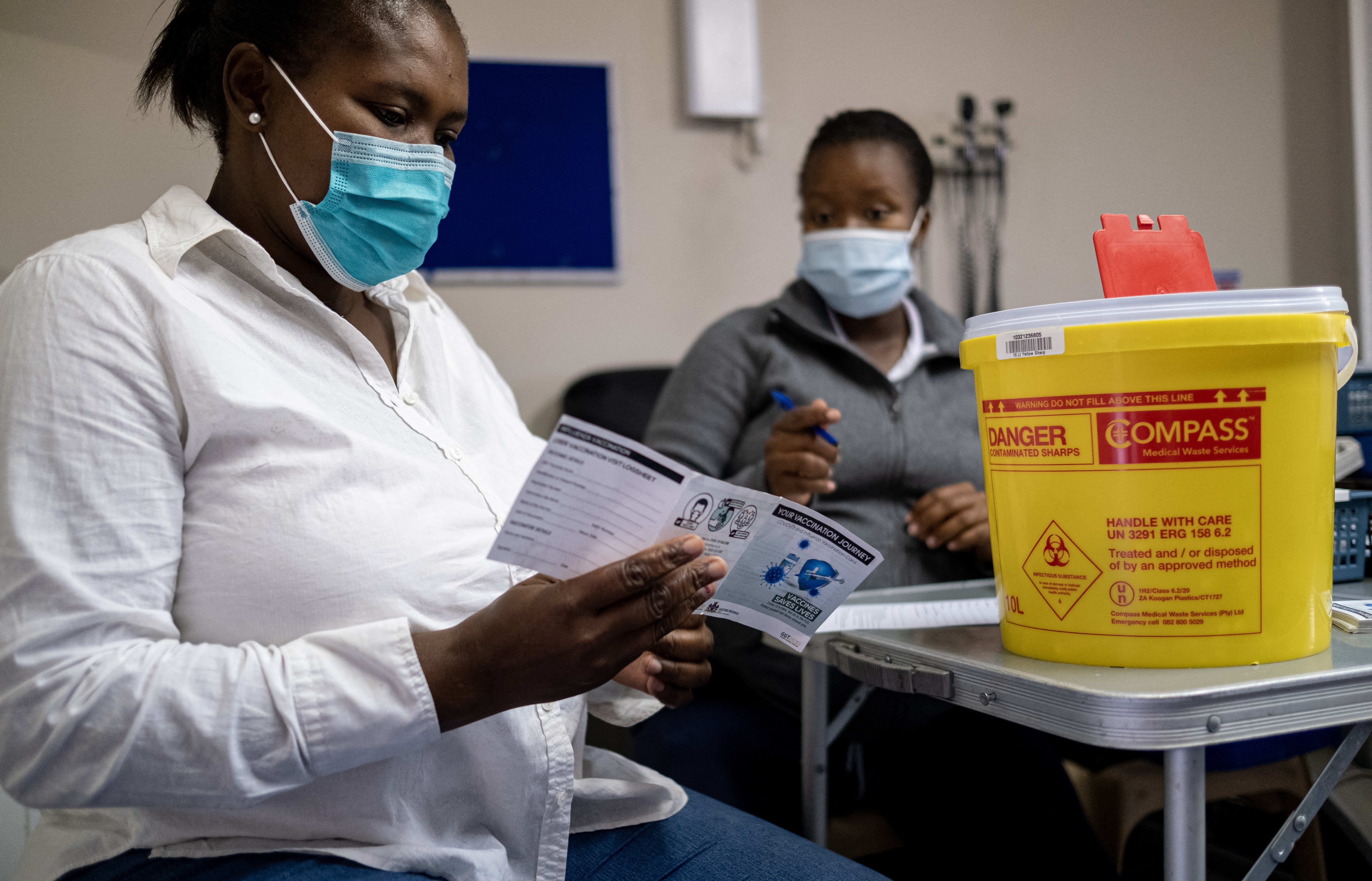 A patient receives a vaccination card after being vaccinated against Covid-19 at the Witkoppen clinic in Johannesburg on 8 December, 2021.