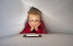 Boy in his bed using smartphone to make a video call. (Photo by CONCEPTUAL IMAGES/SCIENCE PHOTO / PHR / Science Photo Library via AFP)