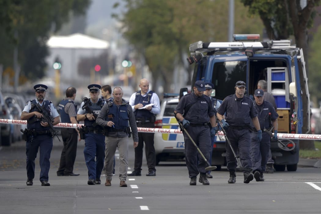 Police officers search the area near the Al Noor mosque, site of one of the mass shootings at two mosques in Christchurch, New Zealand, Saturday, March 16, 2019.