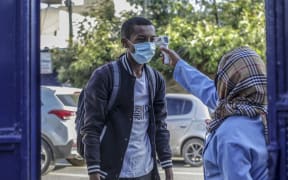 A student has his temperature measured before entering school in Addis Ababa, Ethiopia, on 26 October Schools reopened following a seven-month closure as part of government restrictions to stem the spread of Covid-19.