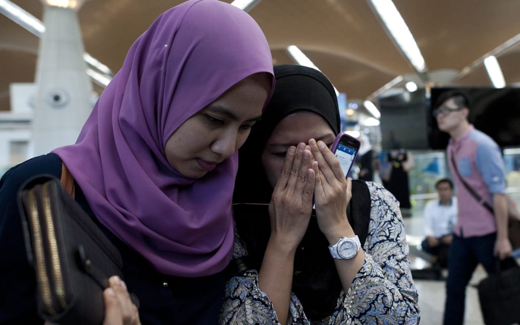 Relatives of a passenger who was on board flight MH17 react over the news at Kuala Lumpur Airport