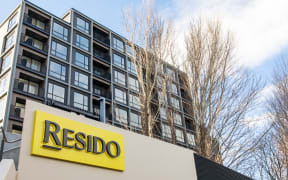 A Resido sign and apartment building