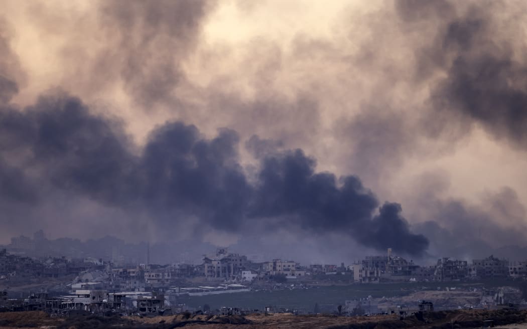 A picture taken from the southern city of Sterod shows smoke rising above destroyed buildings in the northern Gaza Strip during an Israeli army bombardment on January 5, 2025, amid the ongoing war between Israel and Hamas militants. - Gaza's civilian rescuers reported that Israel pounded the Palestinian territory on January 5, killing at least 23 people, even as indirect negotiations for a ceasefire and a hostage release (Photo by Menahem Kahana / AFP)