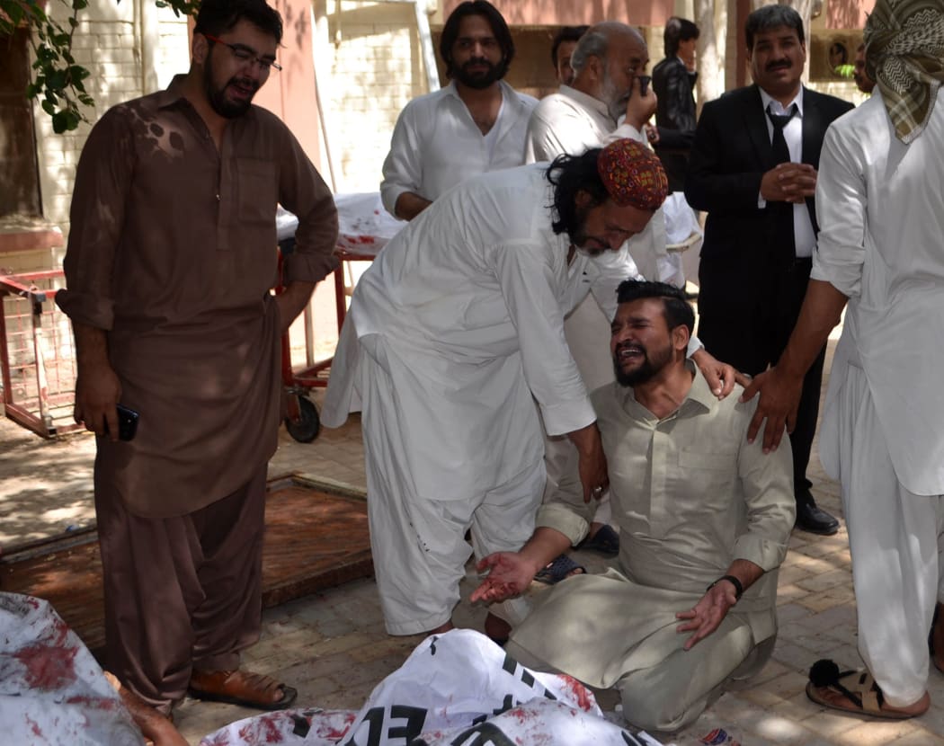 Pakistan relatives mourn beside the body of a blast victim after a bomb explosion at a government hospital premises in Quetta on August 8, 2016.