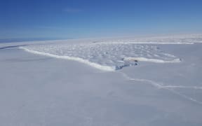 The Ross Ice Shelf meets the smooth annual sea ice at Cape Crozier on Ross Island. The cliffs mark the seaward edge of the largest ice shelf in the world, about the size of France.