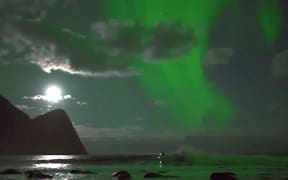 Australian surfer Mick Fanning surfs beneath Northern Lights on the Norwegian archipelago of Lofoten.