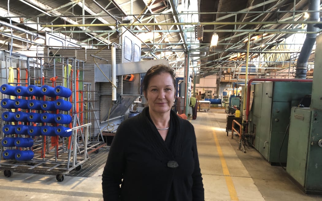 A woman stands on the factory floor at Inter-Weave.