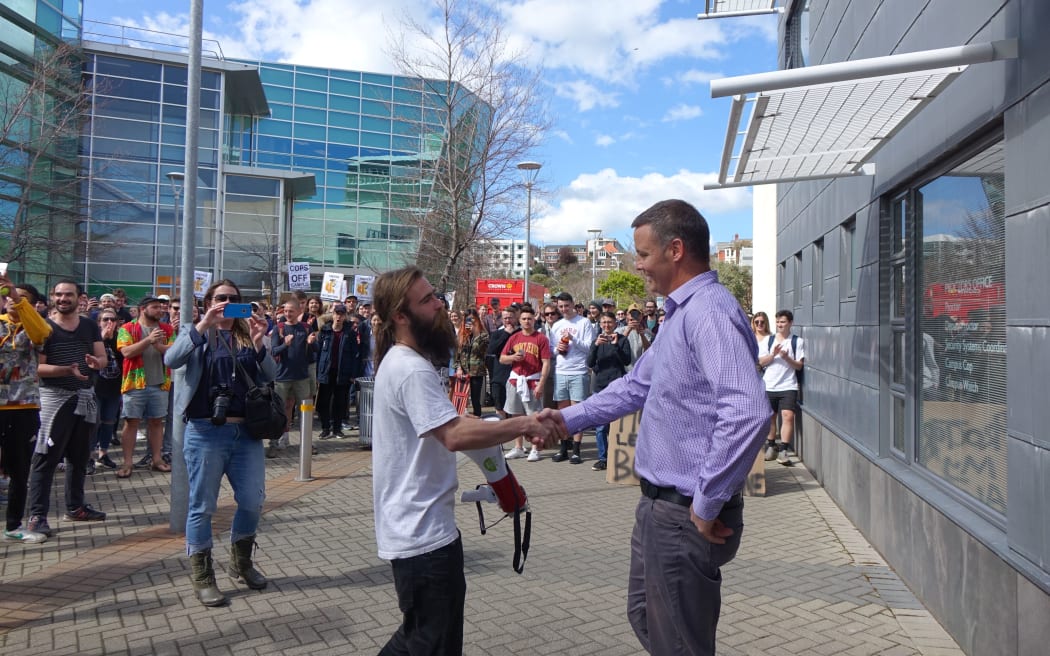 Otago University proctor Dave Scott greets protestors.