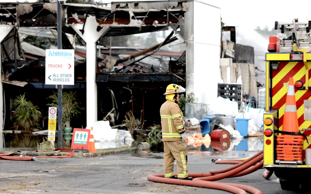 Fire crews at the scene of a recycling plant the day after a large fire engulfed the industrial building in Auckland's North Shore.