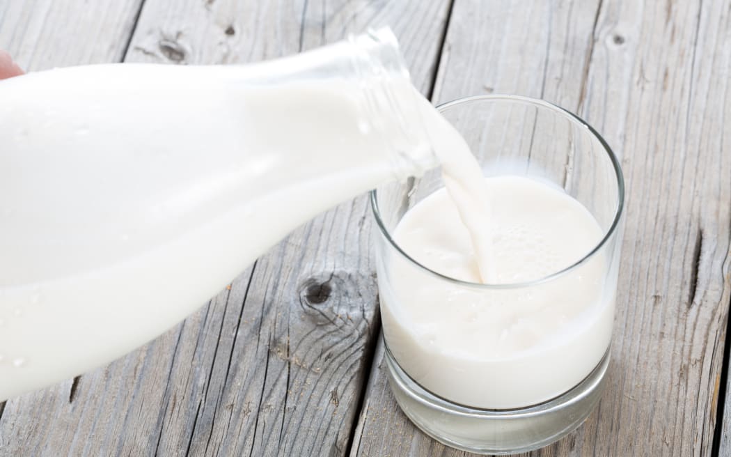 Serving fresh milk in a glass vase on a wooden table