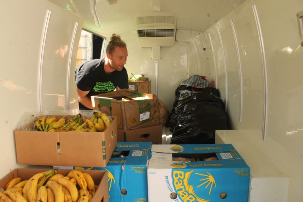 An image of Sam Mentink loading donated food into the KiwiHarvest van.