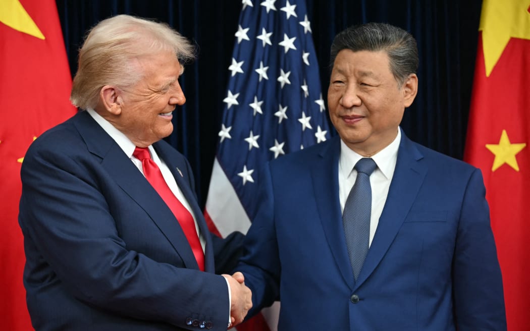 US President Donald Trump (L) and China's President Xi Jinping shake hands as they arrive for talks at the Gimhae Air Base, located next to the Gimhae International Airport in Busan on October 30, 2025. Donald Trump and Chinese leader Xi Jinping will seek a truce in their bruising trade war on October 30, with the US president predicting a "great meeting" but Beijing being more circumspect. (Photo by ANDREW CABALLERO-REYNOLDS / AFP)