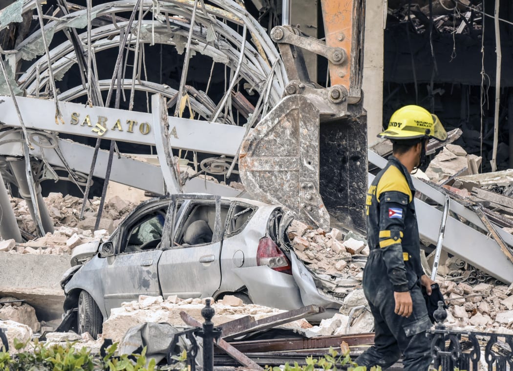 A rescuer helps after a huge blast wrecked the Saratoga Hotel in Havana on 6 May 2022.