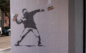 WASHINGTON, DC - AUGUST 31: Banksy-style posters depicting a protester throwing a sandwich at Secretary of Defense Pete Hegseth appear in the Georgetown neighborhood on August 31, 2025 in Washington, DC. The inspiration for the art, "Sandwich Guy" Sean Dunn has been charged with misdemeanor assault for hitting an ICE agent with a sandwich after a grand jury decided not to indict him on felony charges. The Trump administration has deployed federal officers and the National Guard to the District in order to place the DC Metropolitan Police Department under federal control and assist in crime prevention in the nation's capital.   Andrew Leyden/Getty Images/AFP (Photo by Andrew Leyden / GETTY IMAGES NORTH AMERICA / Getty Images via AFP)