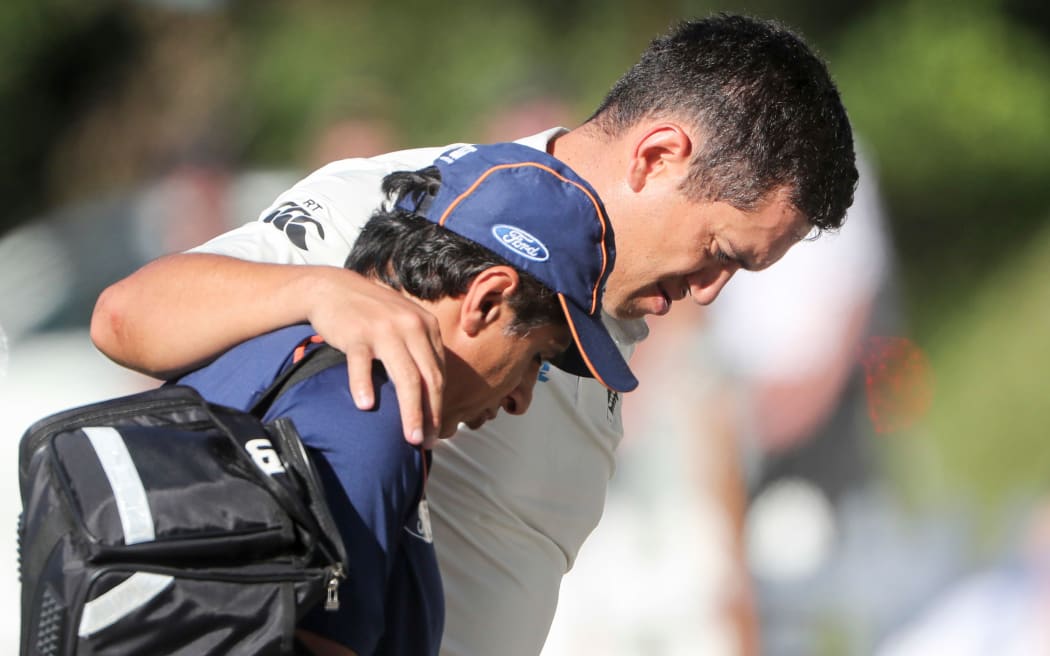 Ross Taylor is helped from the field after suffering a calf injury.