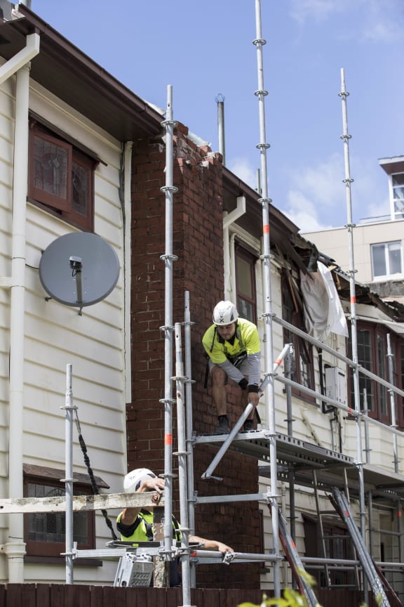 Workers repair earthquake-damaged building on Pipitea St, Wellington.