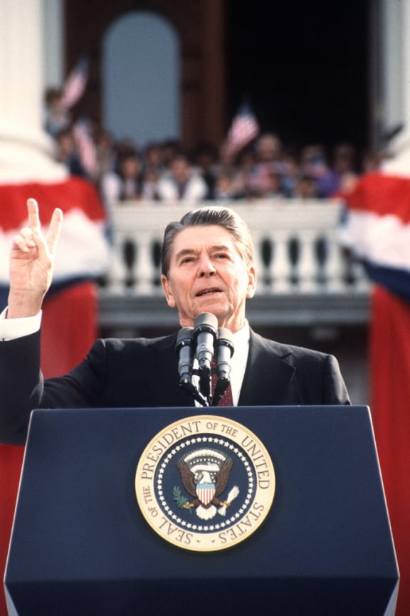 US President and Republican presidential candidate Ronald Reagan makes the V sign as he addresses supporters at an electoral meeting in November 1984, a few days before the american presidential election. (Photo by DON RYPKA / AFP)