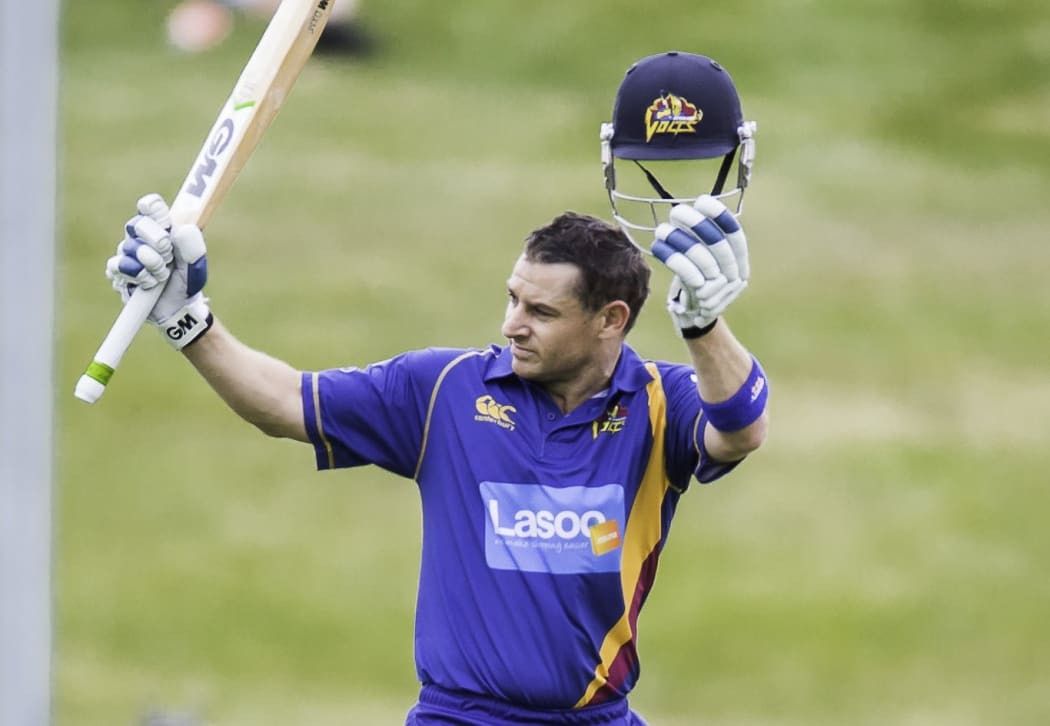 Nathan McCullum lifts his bat after scoring a century in the domestic one-day competition.