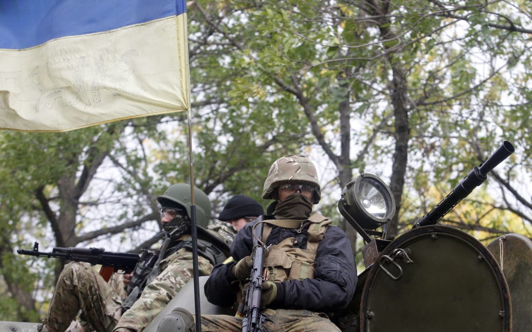 Ukrainian servicemen sit atop of an armored personnel carrier as they patrol in Donetsk region.