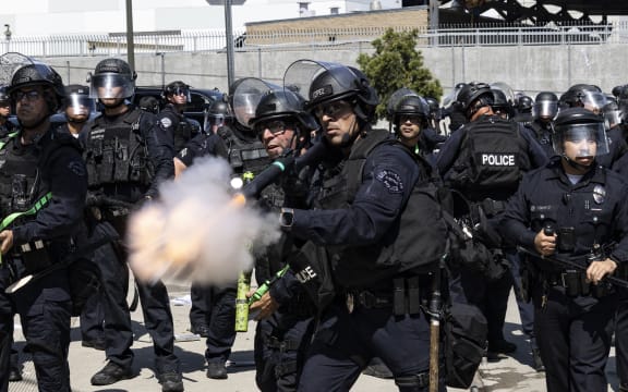 Law enforcement fire less-lethal munitions at protesters during clashes outside the federal building in Los Angeles, California, on June 8, 2025, following federal immigration operations. US President Donald Trump deployed 2,000 troops on June 7 to handle escalating protests against immigration enforcement raids in the Los Angeles area, a move the state's governor termed "purposefully inflammatory." Federal agents clashed with angry crowds in a Los Angeles suburb as protests stretched into a second night Saturday, shooting flash-bang grenades and shutting part of a freeway amid raids on undocumented migrants, reports said. (Photo by ETIENNE LAURENT / AFP)