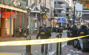 FBI investigators arrive at the scene where the white Ford F-150 pickup truck that crashed into a work lift after allegedly driving into a crowd of New Year's revelers in the French Quarter of New Orleans, Louisiana, on January 1, 2025. - At least 10 people were killed and 30 injured Wednesday when a vehicle plowed overnight into a New year's crowd in the heart of the thriving New Orleans tourist district, authorities in the southern US city said. (Photo by Matthew HINTON / AFP)
