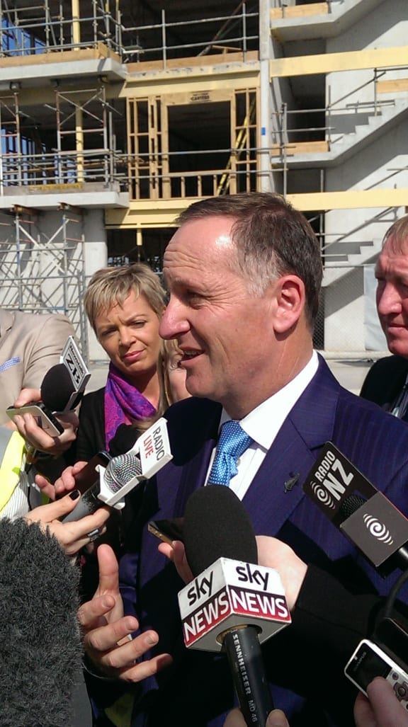 Prime Minister John Key talks to reporters at the Hobsonville housing development.