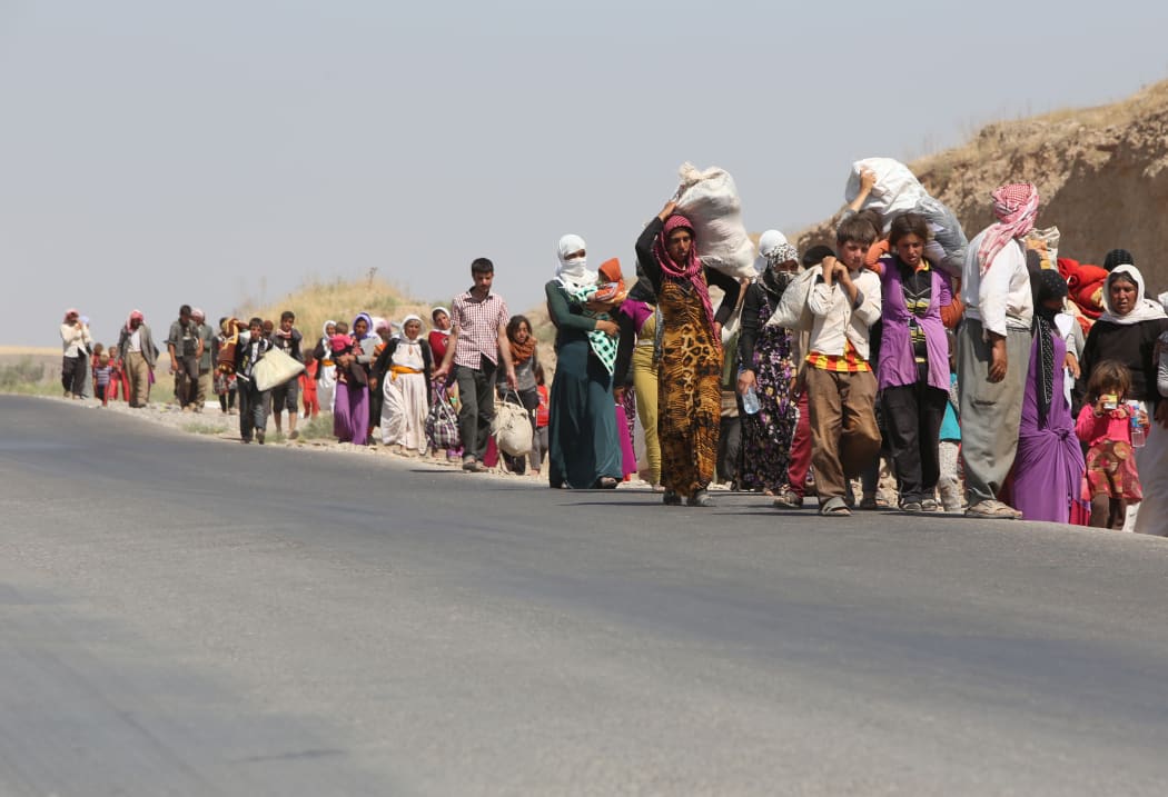 Iraqi families from the Yazidi community cross the Iraqi-Syrian border.