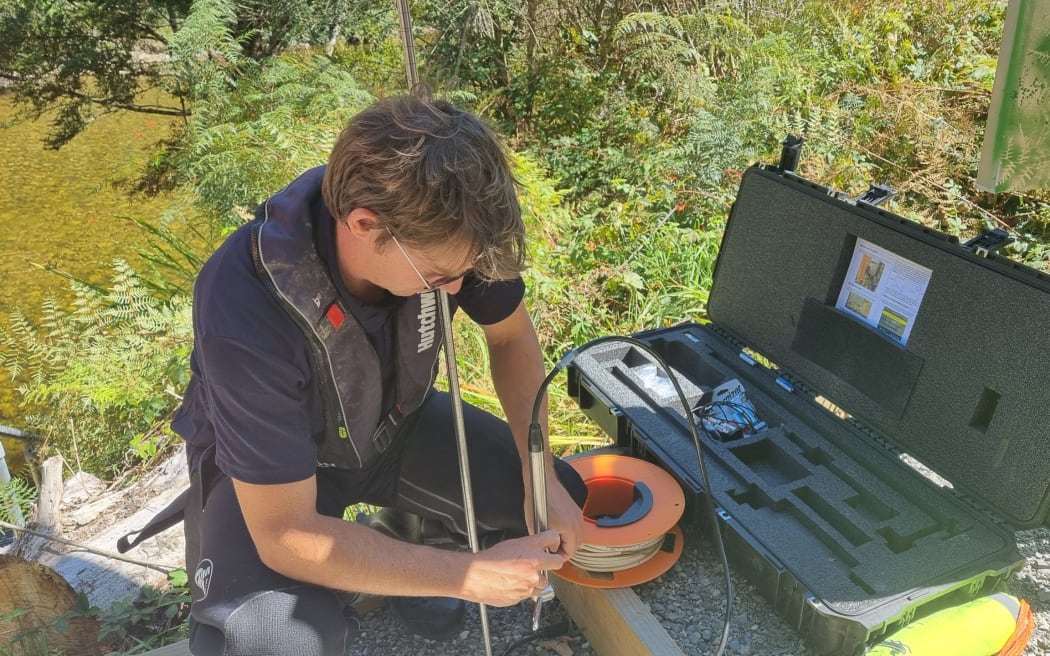 Hydrology manager Samwell Warren working on tech equipment to record flow in the Inangahua River at new telemetry site.