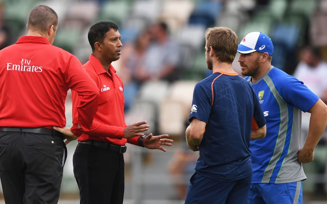 Umpires and captains Kane Williamson and Aaron Finch discuss conditions at McLean Park during the abandoned Chapell-Hadlee match.