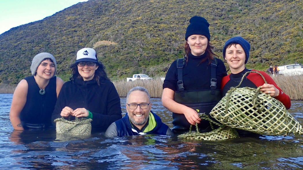 Amber McEwan (second from left) and Holden Hohaia (centre) were part of the small team that braved the wintry waters of Lake Kohangapiripiri to collect 150 kakahi.