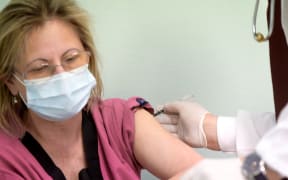 Zsuzsanna Varnai, doctor at the South Pest Central Hospital, receives a vaccination against the novel coronavirus (Covid-19) by Pfizer and BioNTech, from chief infectiologist Janos Szlavik at the South Pest Central Hospital in Budapest on December 26, 2020.