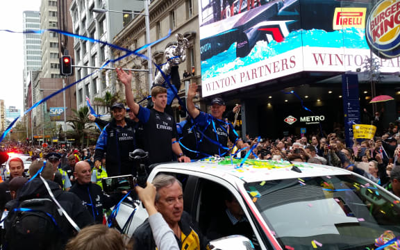 Peter Burling and Team NZ wave to crowds on Queen Street
