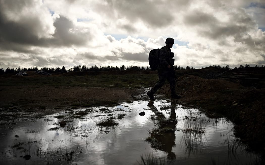 A Ukrainian soldier walks through water during a training exercises with French soldiers at a French military camp in France in November 2023. On their stomachs, the Ukrainian soldiers advance slowly at the edge of the forest in support of an assault group that is seizing the enemy trench: in a military camp in France, they are being trained in combat before leaving for the front. (Photo by OLIVIER CHASSIGNOLE / AFP) / EMBARGO UNTIL MONDAY NOVEMBER 13, 2023,  00.01
